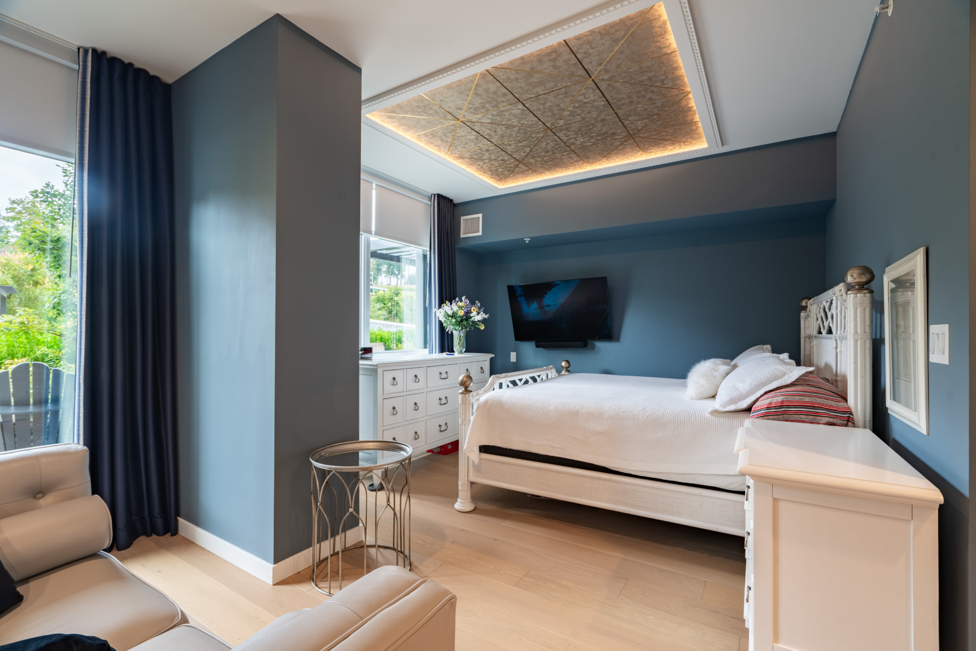 Primary bedroom with garden outlook and coffered ceiling detail