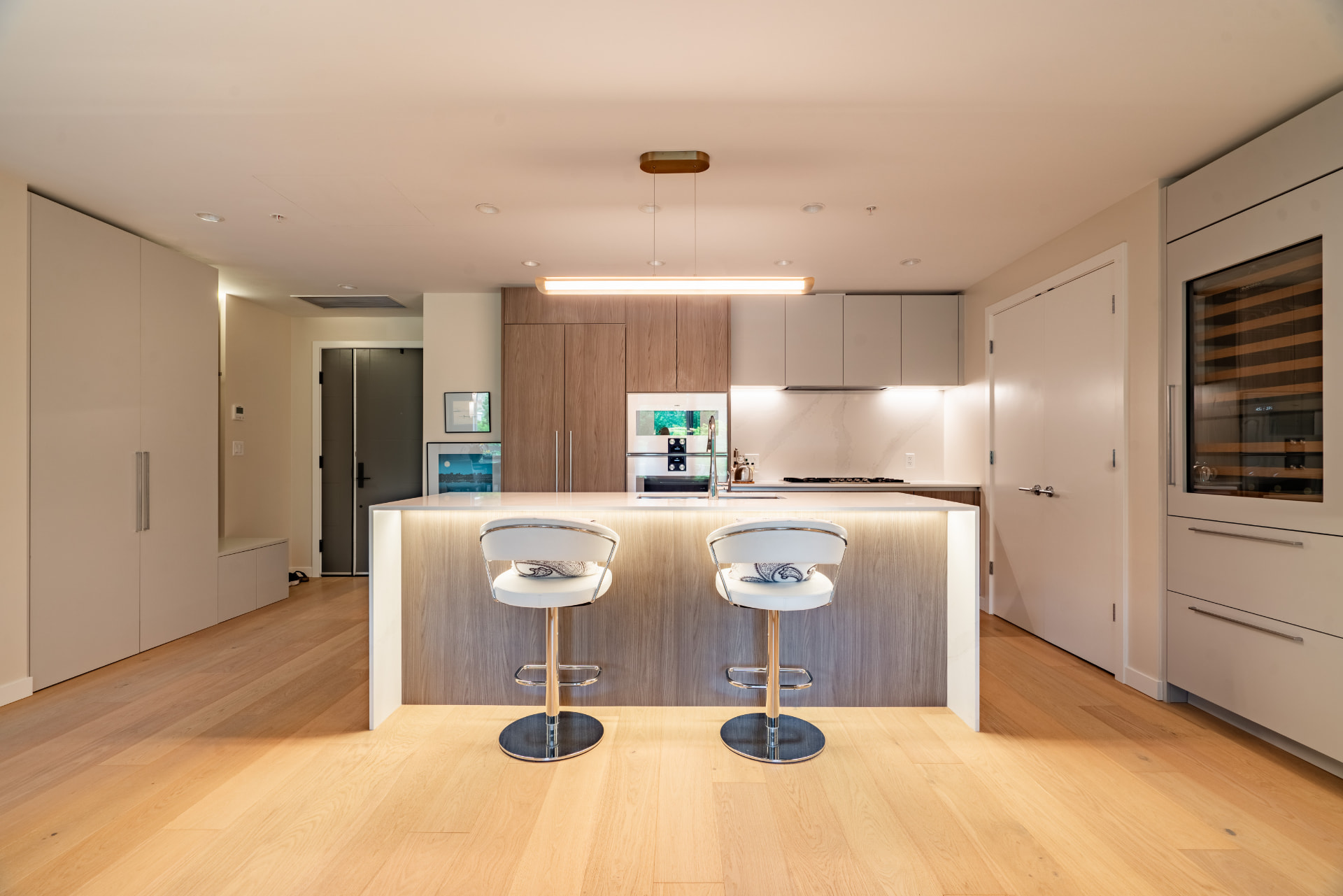 Modern kitchen with quartz island, oak cabinetry, and integrated appliances